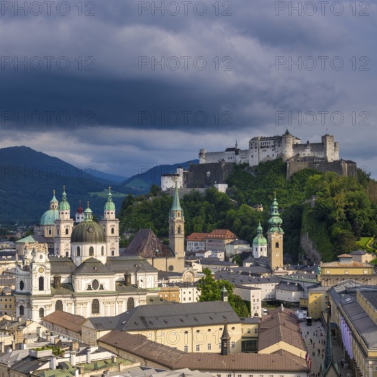 View of Salzburg's historic city centre with Hohensalzburg Fortress in the background under dramatic clouds, Salzburg, Salzburger Land, Austria, Europe