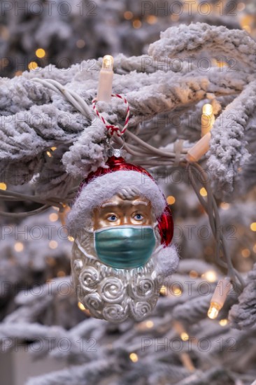 Symbolic image of Christmas in the Corona crisis, Father Christmas figure, Christmas tree decoration, with mouth and nose mask, everyday mask