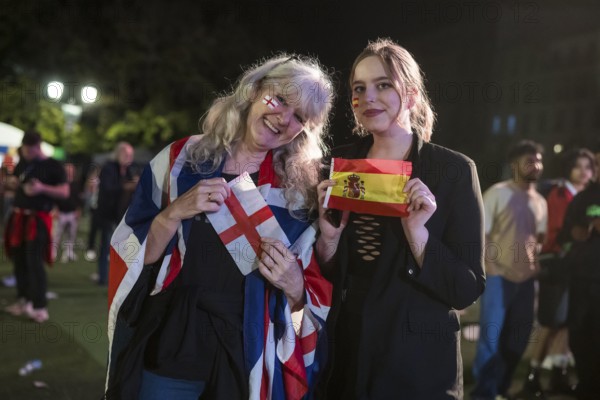 Cathreen (born in England and fan of the English team) together with her daughter Jamie (living in Berlin and fan of the Spanish team) at the fan zone at the Brandenburg Tor after the final match between Spain and England at the European Football Championship, Berlin, 14 July 2024