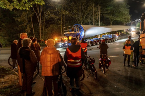 Transport of a 68 metre long, 22 tonne blade of a wind turbine, here in Schwelm, onlookers, with a self-propelled Blade-Lifter vehicle, over a 40 km long route, over 2 nights, in the Bergisches Land, through towns, villages, over country roads, narrow through roads, to the construction site of the wind turbine near Hagen, North Rhine-Westphalia, Germany, Europe