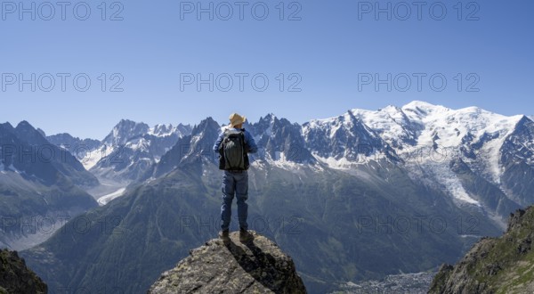 Mountaineer standing on a rock, mountain landscape with mountain peaks Grandes Jorasses, Aiguille du Midi and Mont Blanc, Mont Blanc massif, Aiguilles Rouges, Chamonix-Mont-Blanc, Haute-Savoie, France, Europe