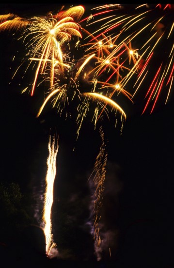 New Year's Eve fireworks, vivid fireworks in the night sky with golden, yellow and red streaks of light and sparks, many fireworks, rockets, New Year's Eve rockets in the dark, sparkling trails of light in the dark sky, stars, star-shaped, shining lights, pyrotechnics, Germany, Europe