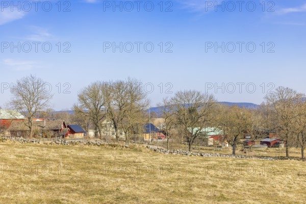 Landscape view at a small village med hus och lador on the Swedish countryside a sunny spring day, Sweden, Europe