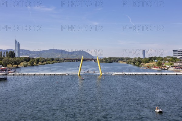 View of a river with bridge, surrounded by mountains and architecture, Vienna