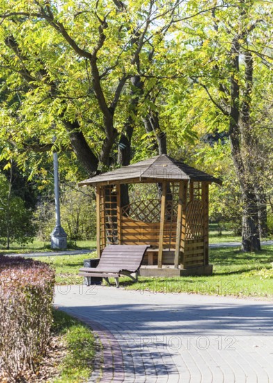 Gazebo and a bench under the trees in the park