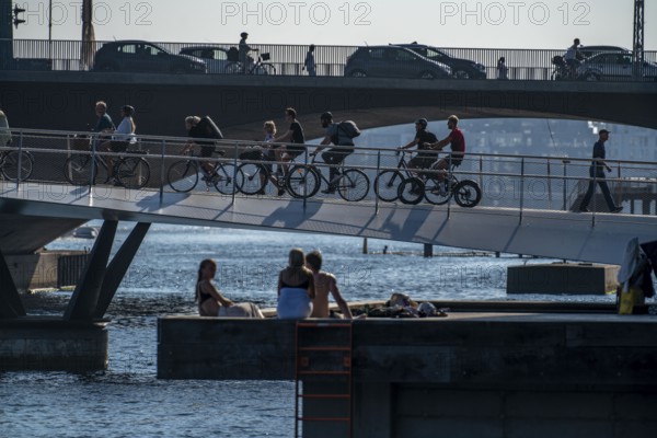 Cyclists on the Lille Langebro cycle and pedestrian bridge, behind it the Langebro road bridge, over the harbour, Copenhagen is considered the cycling capital of the world, 45% of the population travel by bike, Denmark, Europe