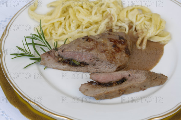 Swabian cuisine, lamb stuffed with prunes, rosemary, herbs, fillets arranged on plates, hand-scraped spaetzle, gravy, grandmother's cooking, regional, home cooking, typical Swabian, traditional cuisine reinterpreted, food photography, studio, Germany, Europe