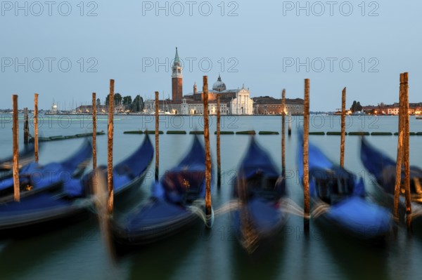 Venetian gondolas near St. Mark's Square in the evening light, blue hour, in the background the monastery of San Giorgio Maggiore, district of San Marco, Venice, Veneto region, Italy, Europe