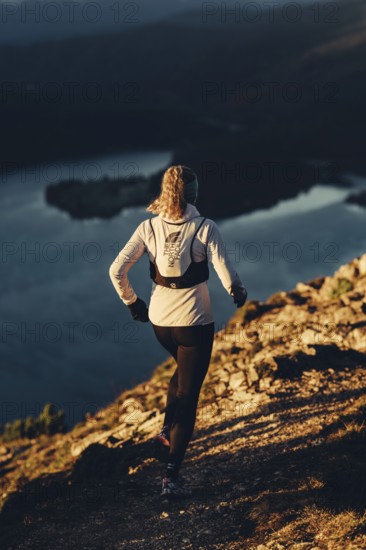 Trail running in autumn on the Jochberg on Lake Walchensee against the wonderful backdrop of the Alps, Bavaria, Germany, Europe