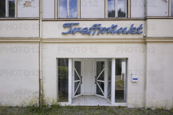 Symbolic photo on the subject of vacant shops in rural areas. The lettering 'Äô Treffpunkt 'Äô hangs on a vacant building, taken in the small town of Ziegenrück in Thuringia. Ziegenrück, 23.07.2024