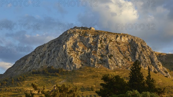 The last rays of the day illuminate a mountainous horizon with a historic castle, Archaic Castle, Akrokorinthos, Corinth, Peloponnese, Greece, Europe