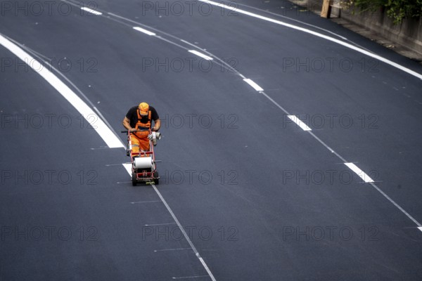 Marking work after the renewal of the road surface on the A40 motorway between the Kaiserberg junction and Mülheim-Heißen, in the direction of Essen, over a length of 7.6 kilometres, with whisper asphalt, so-called open-pored asphalt, 10-day closure of the motorway, North Rhine-Westphalia, Germany, Europe