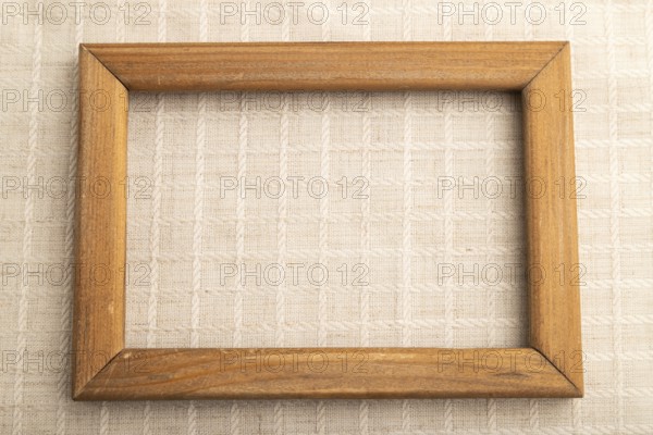 Wooden frame on smooth white linen tissue. Top view, flat lay, natural textile background and texture