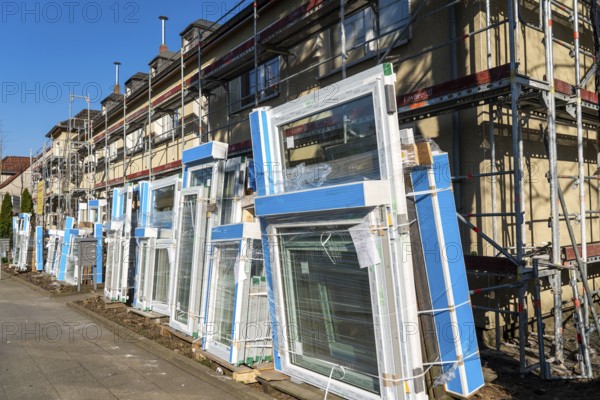 Energy-efficient refurbishment of residential buildings, older apartment block is scaffolded, gets thermal insulation and new windows, Germany, Europe
