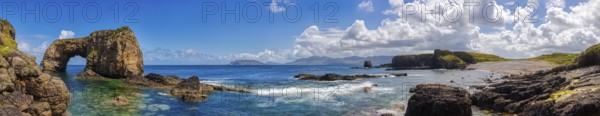 Sweeping panorama with ocean, rocks and cloudy sky in natural landscape, Great Pollet Sea Arch