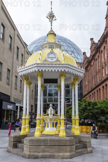 Yellow historic pavilion in a public square surrounded by old buildings, Belfast