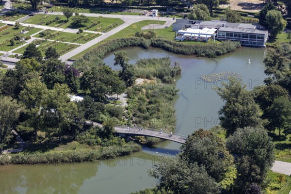 A green park with a bridge and river surrounded by lush vegetation, Vienna