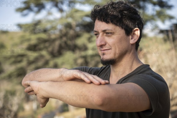 A man practicing martial arts, his posture reflecting determination and serenity as he connects with the nature around him
