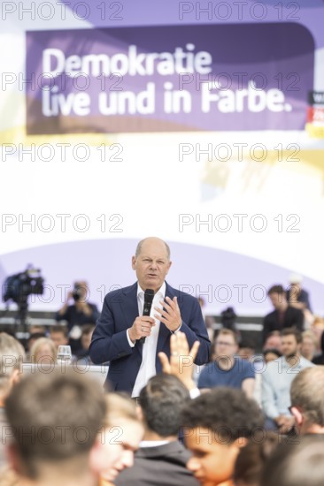 Olaf Scholz (Federal Chancellor, SPD) speaks to members of the Hamburg Fire Brigade at the Germany Dialogue on the topic Together for Democracy in the dialogue forum at Celebrating Democracy. / The Basic Law turns 75, together it will be a celebration in the background a banner with the inscription Democracy live and in colour, Berlin, 24.05.2024