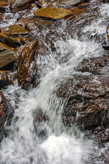 Water from a small stream running over rocks in Minas Gerais, Minas Gerais, Brazil, South America
