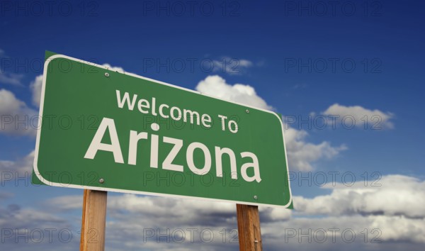Welcome to arizona green road sign over blue sky with some clouds