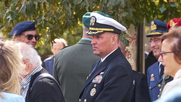Greek naval officer in uniform talking to several people, Visit of the Federal President Frank-Walter Steinmeier in Kandanos on 31 October 2024, Federal President, Frank-Walter Steinmeier, memorial, war crimes, Nazis, Wehrmacht crimes, World War II, Kandanos, southwest Crete, Crete, Greek islands, Greece, Europe