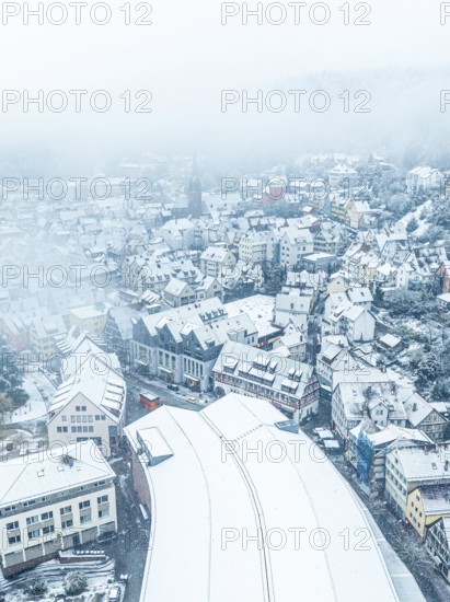 Aerial view of town in winter fog with snow-covered roofs and gloomy atmosphere, Black Forest, Calw, Germany, Europe