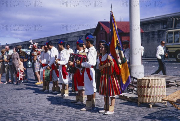 Folk musicians in traditional costume line up to greet cruise ship visitors, 1969, Funchal, Medeira