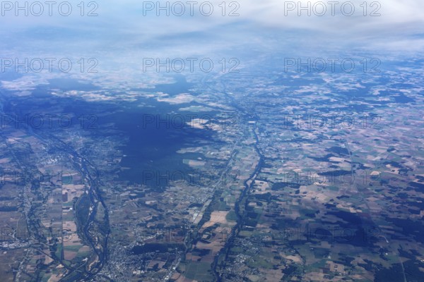 Extensive fields and landscapes under a slightly cloudy sky, flight, aerial view
