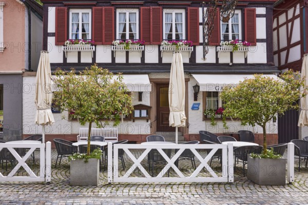 Outdoor area with tables and chairs, planters, half-timbered house, Gasthaus Hotel Hecht, main street, Wolfach, Black Forest, Ortenaukreis, Baden-Württemberg, Germany, Europe