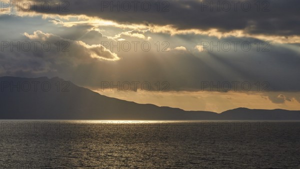 Dramatic cloudy evening sky, sun rays breaking through clouds, sun reflection on the sea, sunset, evening light, Rodopou Peninsula, Gramvoussa Peninsula, West Crete, Crete Island, Greece, Europe
