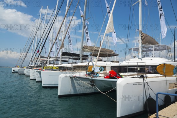 Row of catamarans in the harbour with clear blue sky and calm sea, Mediterranean yacht show, harbour, Nafplio, Nauplia, Nauplion, Nafplion, Argolis, Argolic Gulf, Peloponnese, Greece, Europe