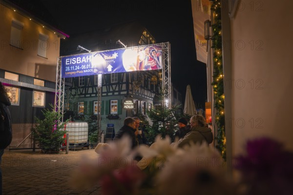 Evening street scene with people, illuminated billboard and cosy Christmas atmosphere, Christmas market, Nagold, Black Forest, Germany, Europe