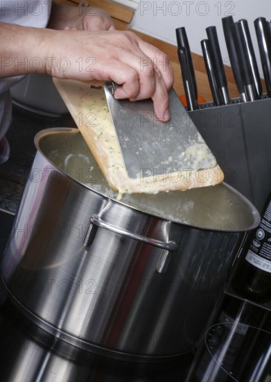 Swabian cuisine, preparation of herb spaetzle for roast beef, scraping spaetzle, spaetzle board, dough, cooking pot, savoury, salty, typical Swabian, home cooking, traditional cuisine, men's hands, food photography, studio, Germany, Europe