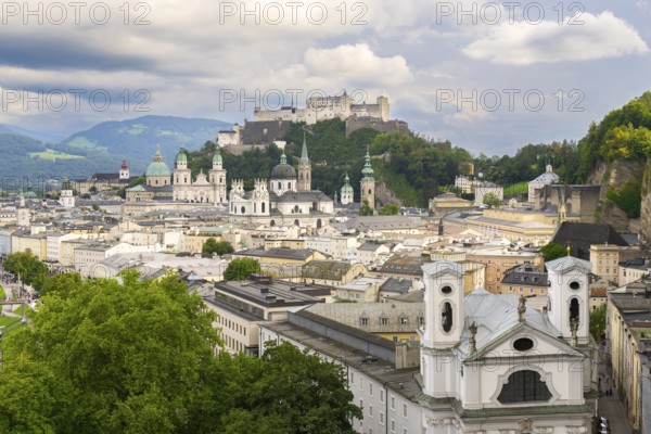View of Salzburg with Hohensalzburg Fortress in the background and the historic city centre in the foreground, surrounded by mountains under a cloudy sky, Salzburg, Salzburger Land, Austria, Europe