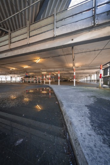 Puddle of water reflects the interior of a multi-storey car park with steel structure, Kaufland Calw multi-storey car park, Calw district, Black Forest, Germany, Europe