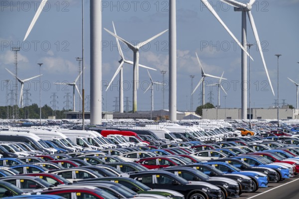 Storage area for new cars in the port of Vlissingen-Oost, vehicles are temporarily stored on over 100 hectares to ship them from Europe to the United Kingdom, Ford cars, others such as models from the Chinese car manufacturer BYD are delivered from here in Europe, wind farm, Netherlands