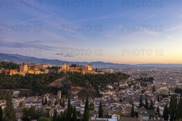 Alhambra and panorama of the city at sunset, surrounded by mountains, Granada