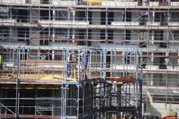 Photo of a large construction site in a newly developed residential area. Several apartment buildings are still under construction