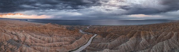 Panorama, landscape of eroded hills, badlands at sunset, Issyk Kul Lake in the background, aerial view, Canyon of the Forgotten Rivers, Issyk Kul, Kyrgyzstan, Asia