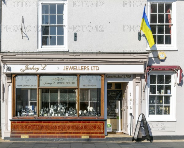 Support for Ukraine, Ukrainian national flag flying outside jeweller shop, Saxmundham, Suffolk, England, UK
