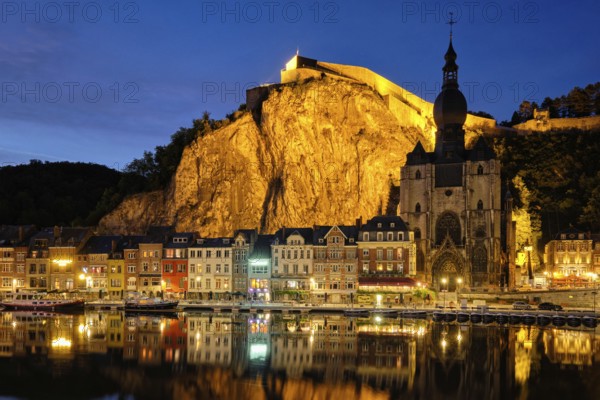 Night view of Dinant town, Collegiate Church of Notre Dame de Dinant over River Meuse and Pont Charles de Gaulle bridge and Dinant Citadel illuminated in the evening. Dinant, Belgium, Europe