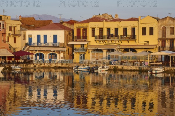 Morning light, sunrise, Venetian harbour, row of houses, colourful houses, reflections in the water, blue cloudless sky, Rethimnon, Central Crete, island of Crete, Greece, Europe