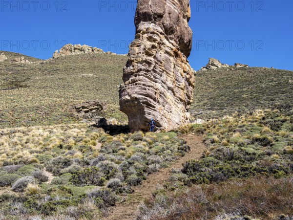 Single hiker at foot of rock formation Piedra Clavada, stand-alone rock tower, Jeinimeni NP, Patagonia, Chile, South America