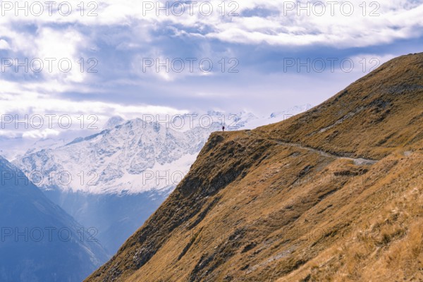A narrow path runs along a mountain ridge with an overwhelming view of the distant vista, Planplatten, Switzerland, Europe