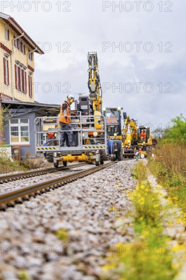 Rail vehicles and workers in a construction environment with houses and plants, track construction Hermann Hesse Bahn, district of Calw, Black Forest, Germany, Europe