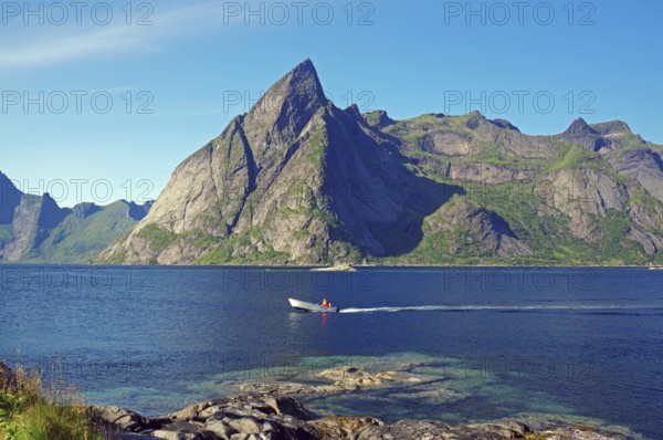 Small boat sailing over the Reinefjorden, high, rugged, mountains, Nordland, Norway, Europe