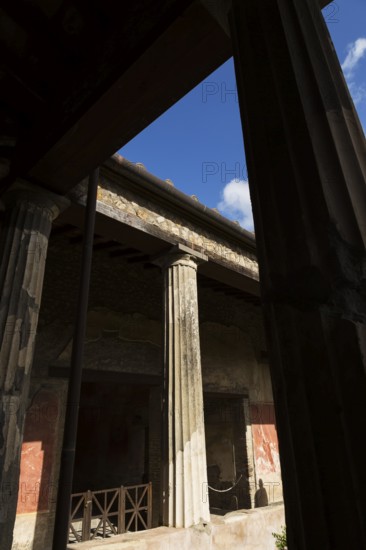 Large old building with silhouetted stone columns at the ancient ruins of Pompeii, Campania region, Italy, Europe