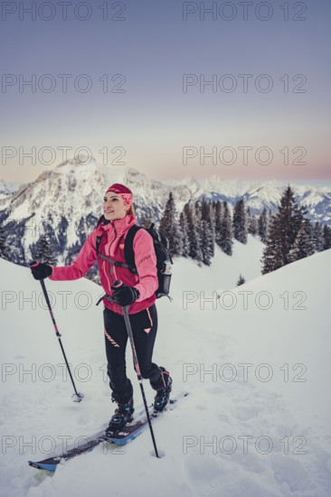 A woman's ski tour at sunrise on the Tegelberg in the Allgäu in the Ammergebirge, Bavaria, Germany, Europe