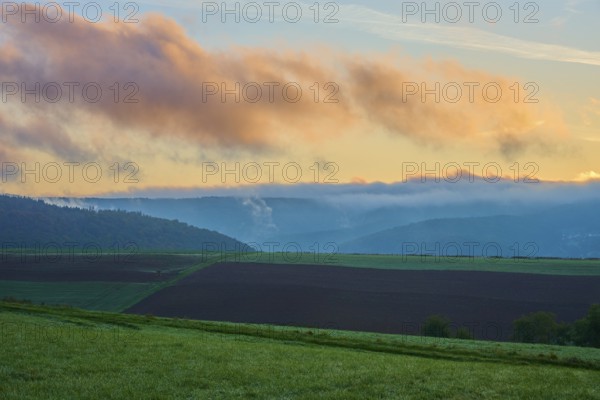 Landscape with fields and mountains in the background, clouds in the sky at sunrise, autumn, Eichelsbach, Elsenfeld, Spessart, Bavaria, Germany, Europe